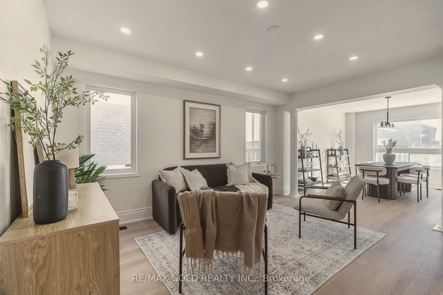 Living room with a charcoal sofa, sling chair and a dining room beyond
