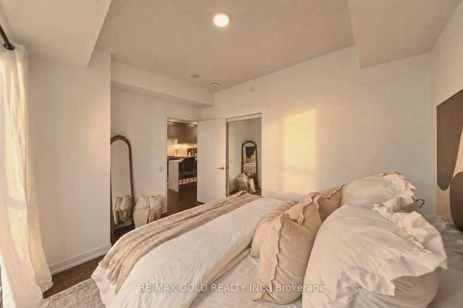 Bedroom in warm evening light with layered white bedding